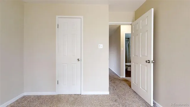a view of empty room with a kitchen
