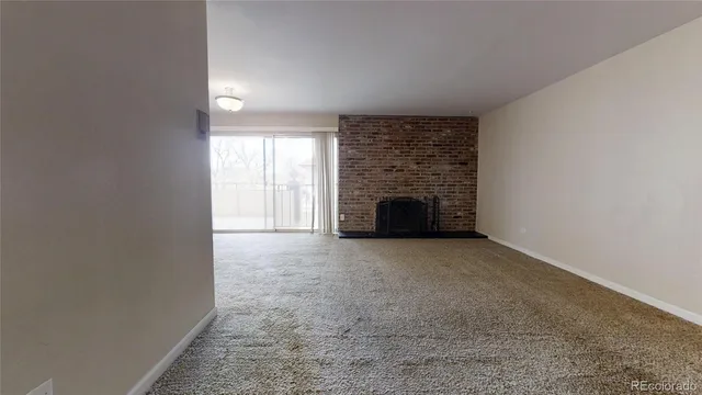 an empty room with fireplace and a window