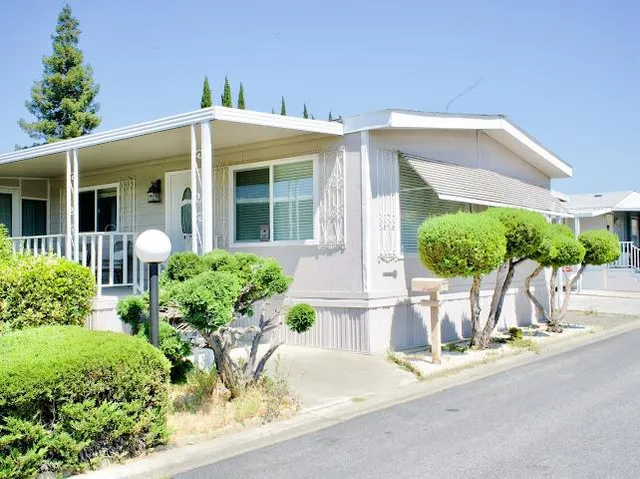 a front view of a house with a yard and potted plants