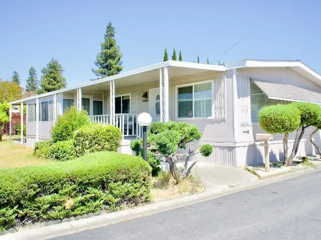 a front view of a house with a yard and potted plants