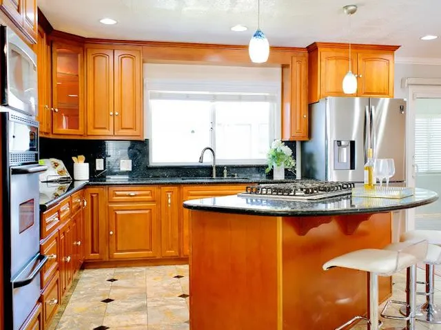 a kitchen with stainless steel appliances granite countertop a stove a sink and a microwave