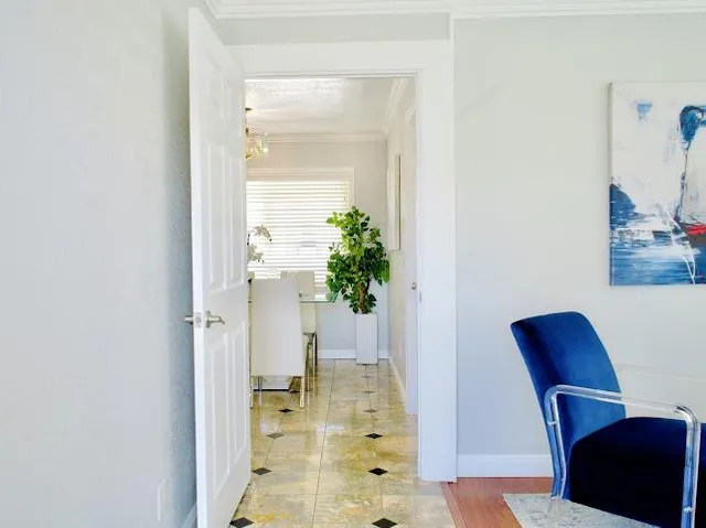 a view of a hallway with wooden floor and a potted plant