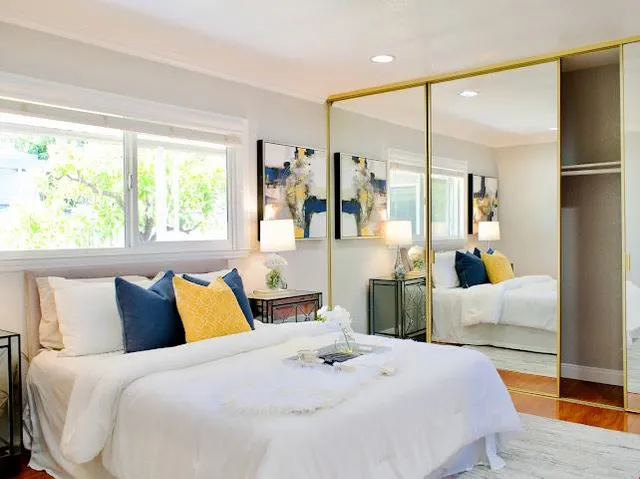 a bedroom with a large bed and a large mirror