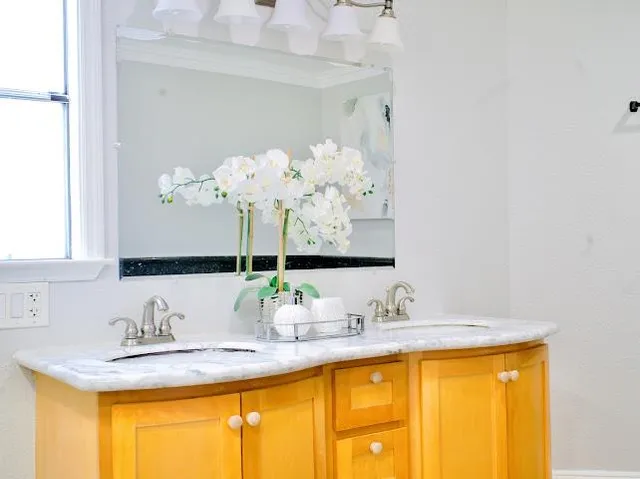 a bathroom with a granite countertop sink and a mirror