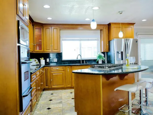 a kitchen with stainless steel appliances granite countertop a stove a sink and a refrigerator