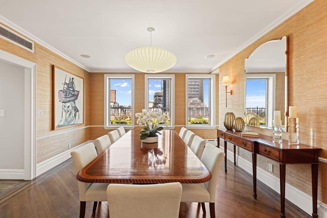 1158 5th Avenue, Unit PHC Manhattan, NY 10128 - Photo 7 of 25 a view of a dining room with furniture wooden floor and chandelier
