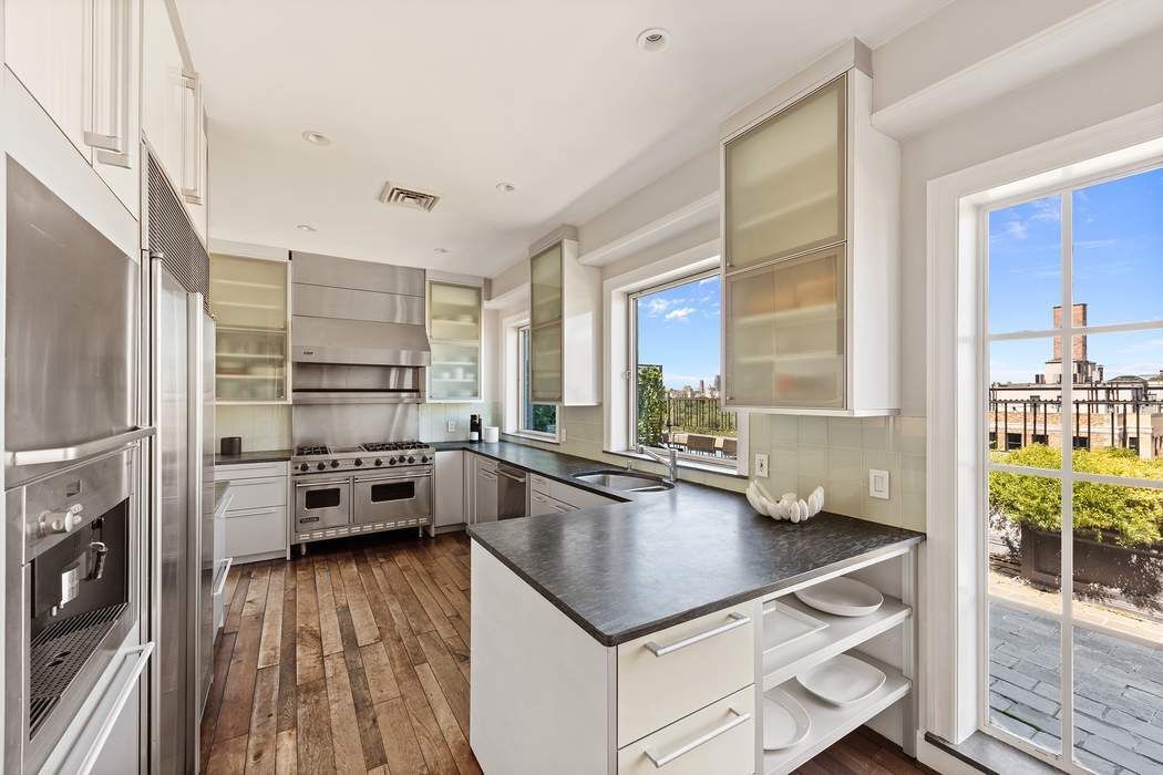 1158 5th Avenue, Unit PHC Manhattan, NY 10128 - Photo 8 of 25 a kitchen with a refrigerator a stove and a wooden floor