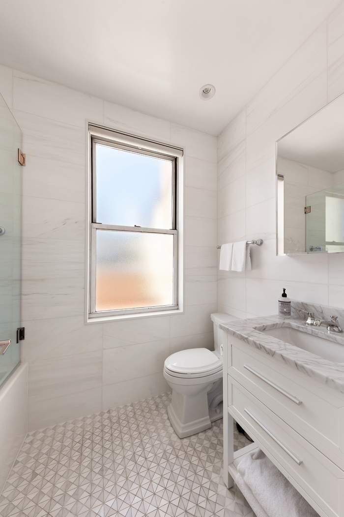 1158 5th Avenue, Unit PHC Manhattan, NY 10128 - Photo 12 of 25 a bathroom with a sink toilet a mirror and window