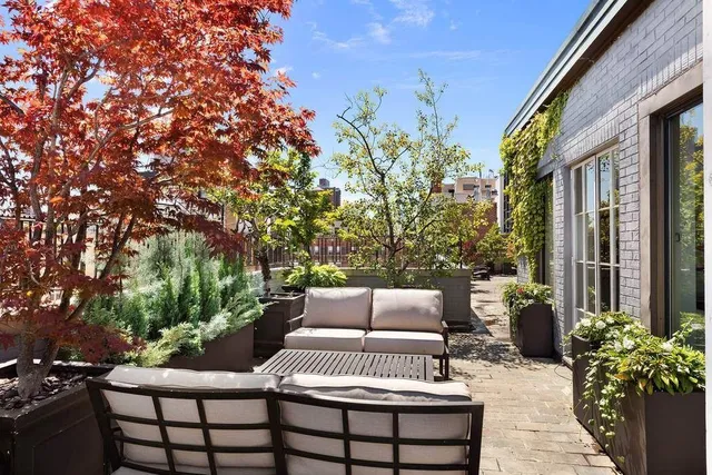 a view of a patio with couches table and chairs and potted plants