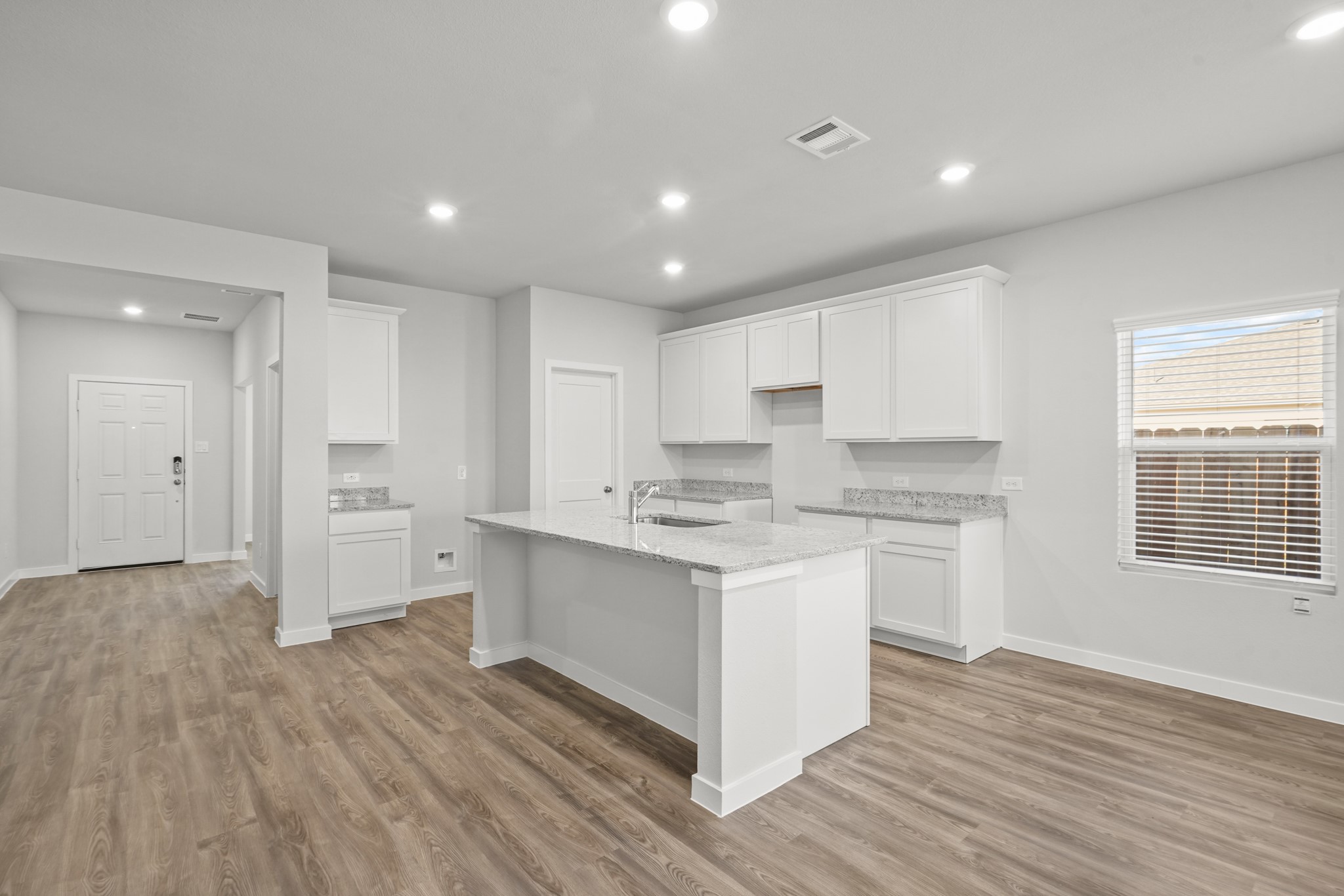 9720 Caney Bend Road Conroe, TX 77303 - Photo 4 of 24 a kitchen with a sink wooden floor and white cabinets