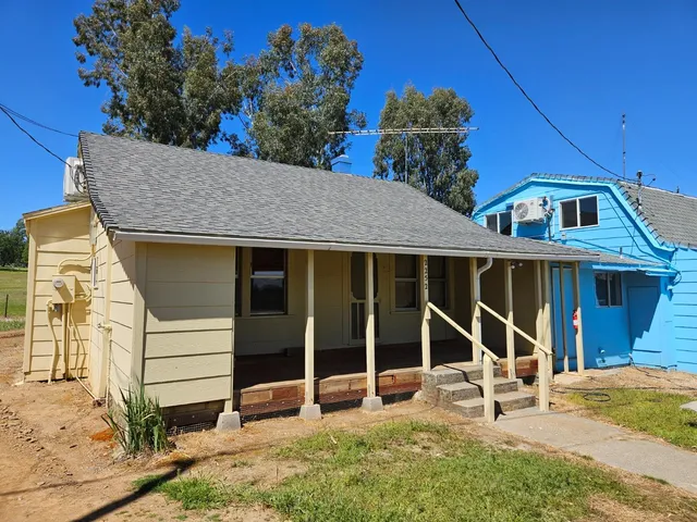 a view of a house with a yard and large windows