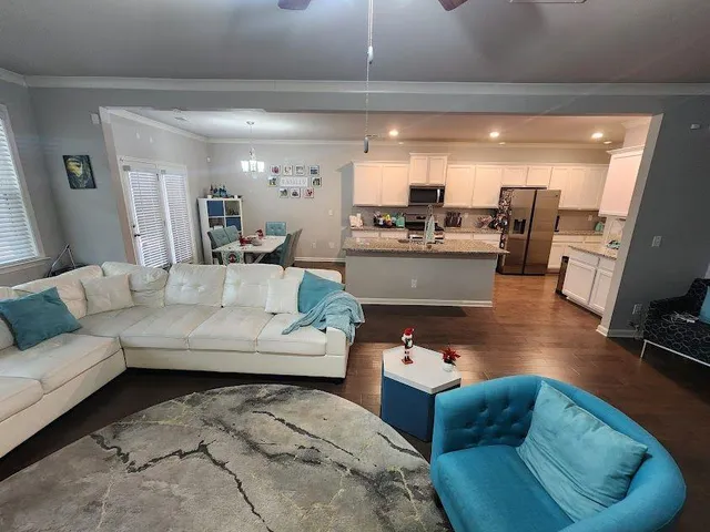 a living room with furniture and view of kitchen