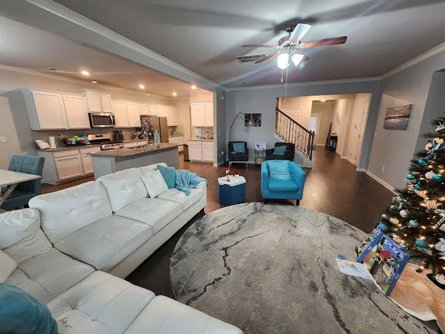 a living room with furniture kitchen and a chandelier