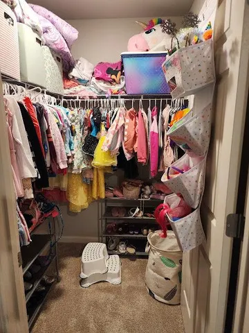 a view of walk in closet with clothes and shoes