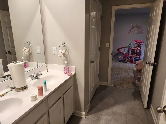 a en suite bathroom with a double vanity sink and a mirror