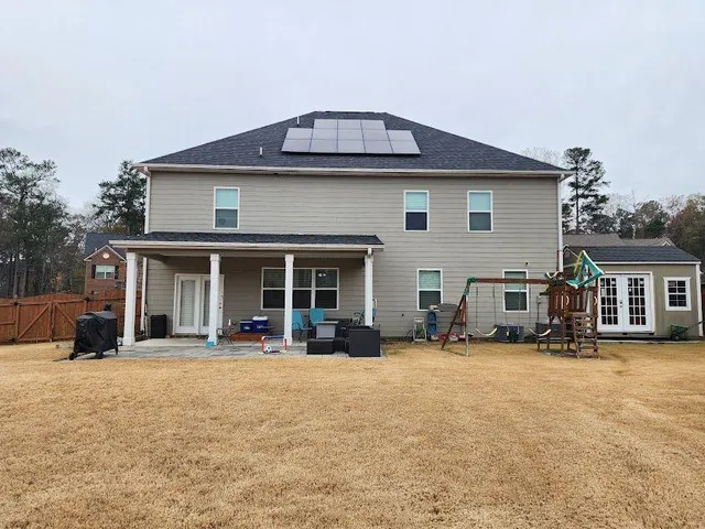a view of a house with large space and a car park front of house