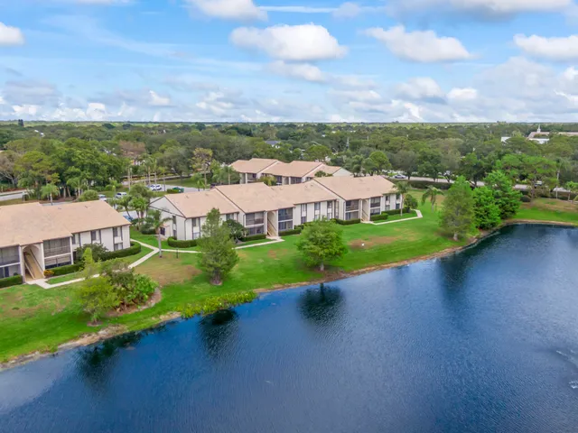 an aerial view of a house with a garden and lake view