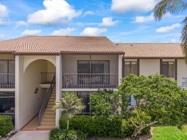 a view of a white house that has a yard