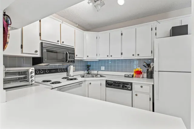 a kitchen with stainless steel appliances white cabinets and a refrigerator