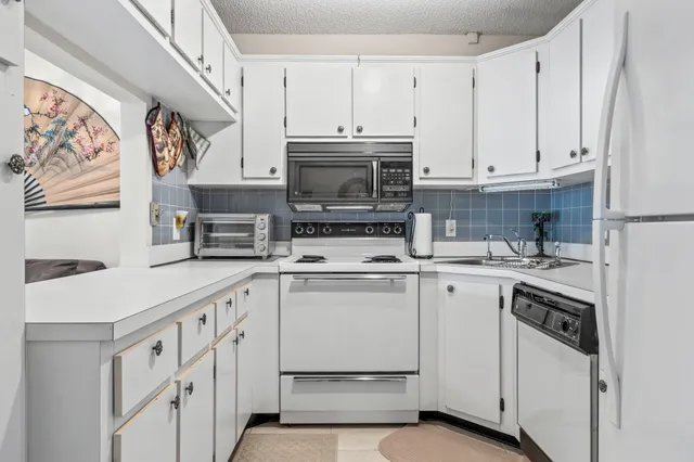 a kitchen with stainless steel appliances granite countertop a stove and a microwave