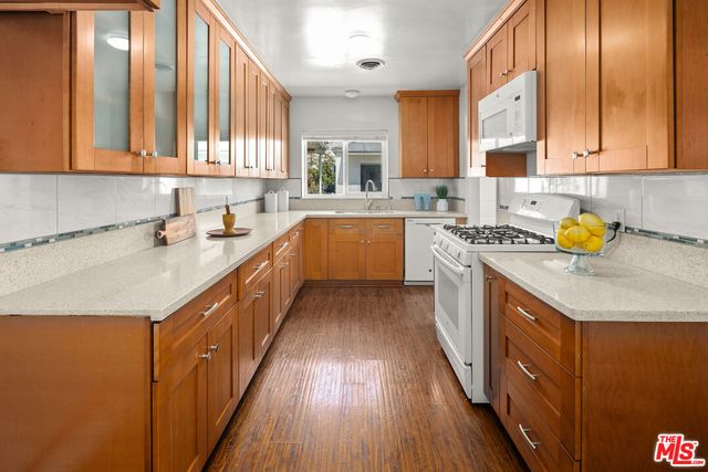 a kitchen with a sink a counter top space cabinets and appliances
