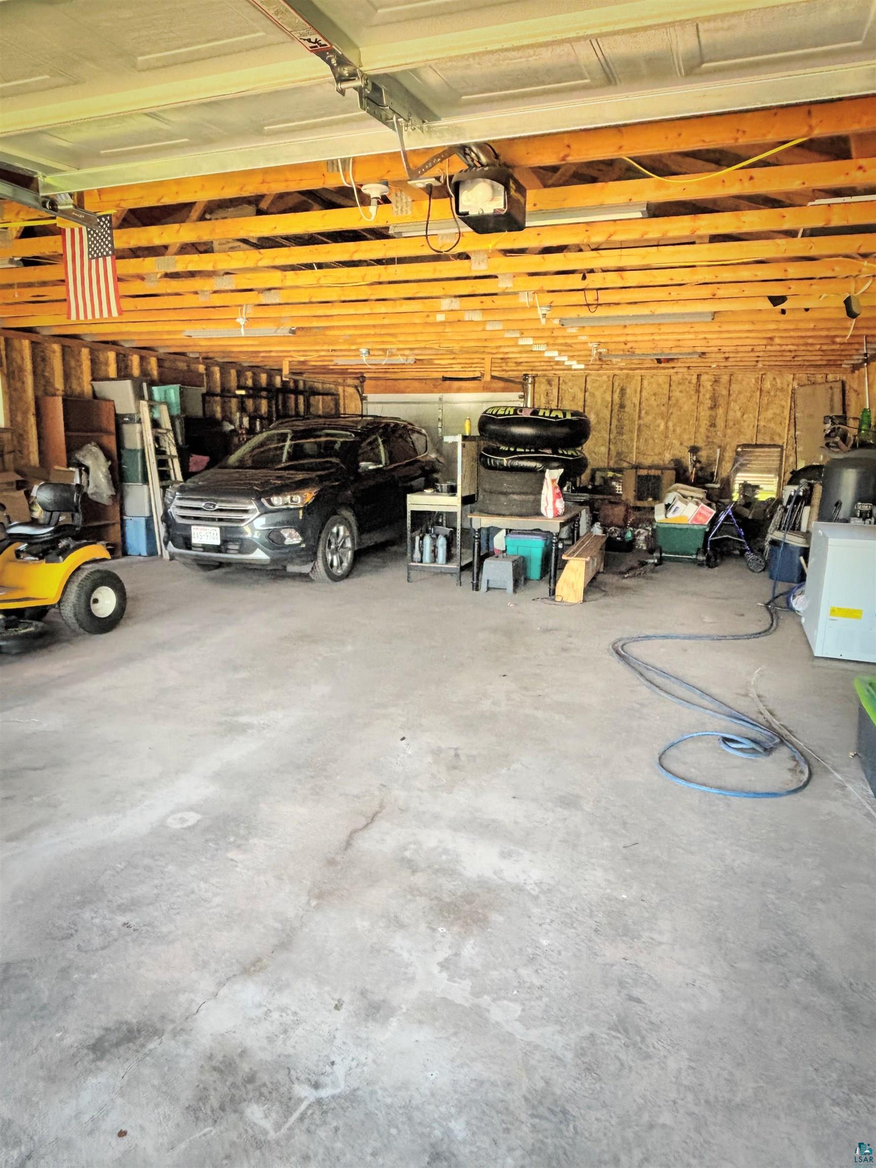 67805 Old County Road High Bridge, WI 54846 - Photo 4 of 11 Spacious garage featuring exposed wood joists, concrete flooring, and ample storage capacity