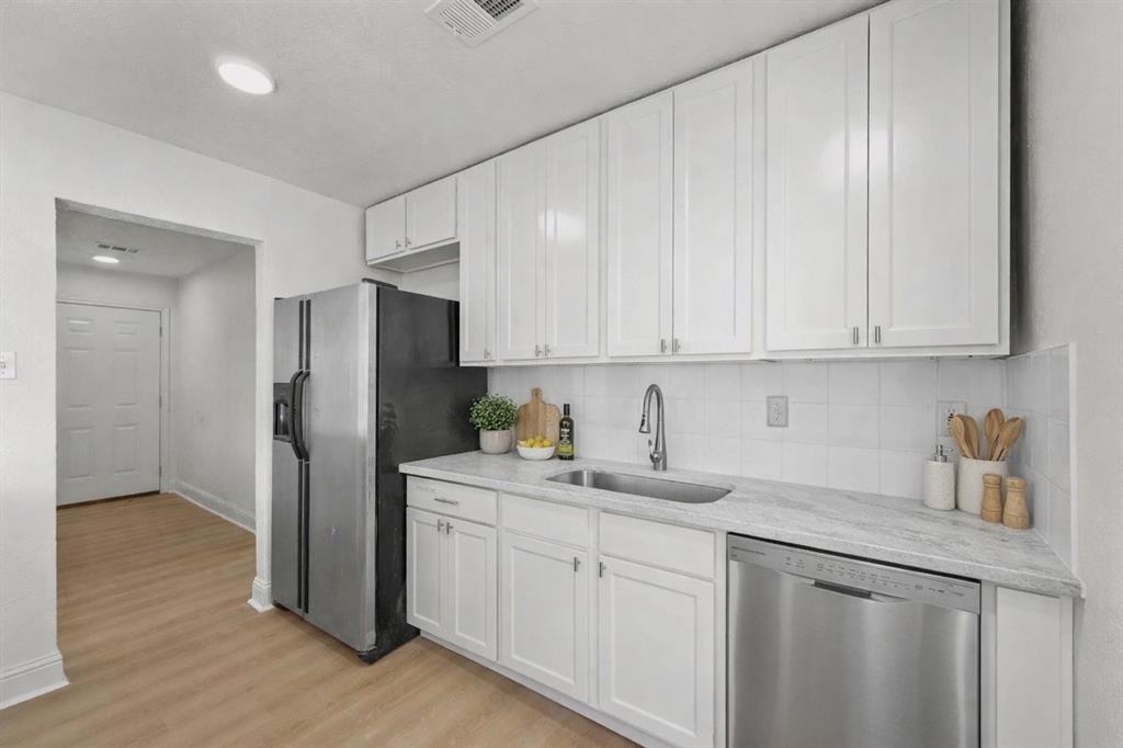5516 Maple Lane Rowlett, TX 75089 - Photo 6 of 18 a kitchen with a refrigerator sink and cabinets