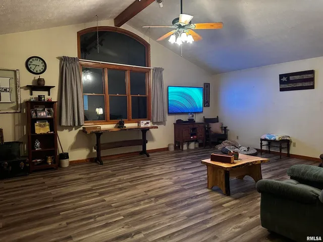 a living room with furniture a ceiling fan and a flat screen tv