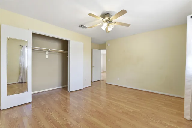 a view of an empty room with wooden floor