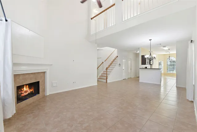 a view of a kitchen and an empty room with a fireplace