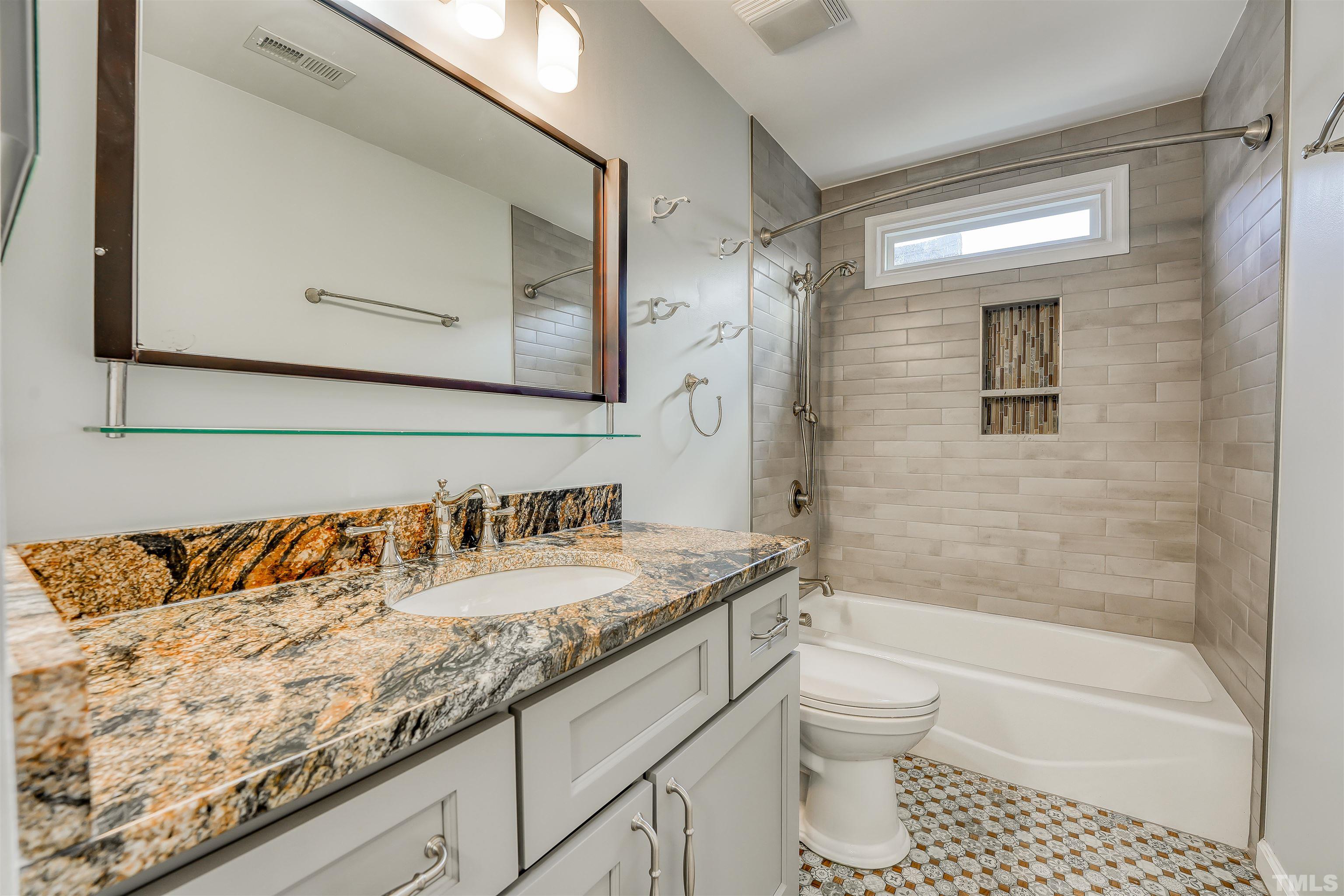 5516 Bridford Place Raleigh, NC 27613 - Photo 17 of 20 a bathroom with a granite countertop sink a toilet and shower