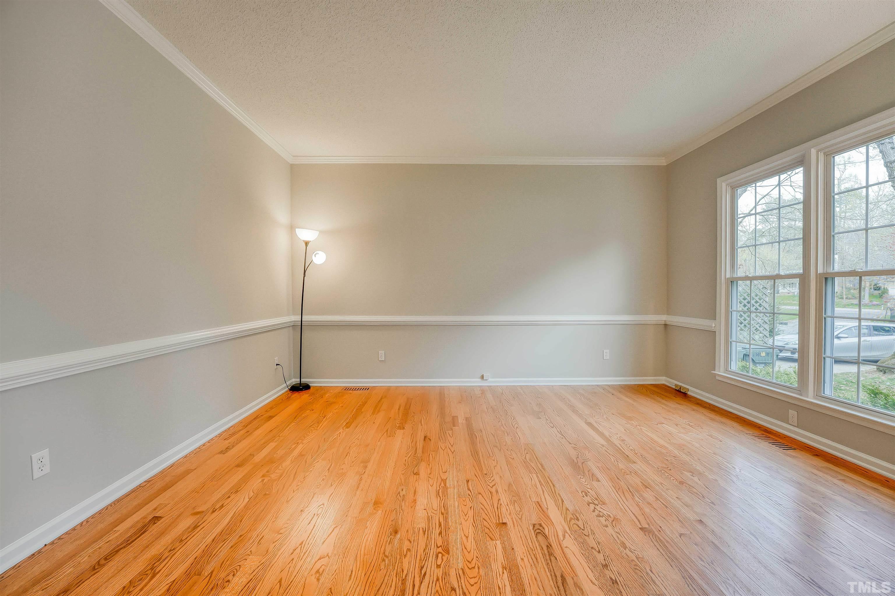5516 Bridford Place Raleigh, NC 27613 - Photo 4 of 20 a view of an empty room with wooden floor and a window