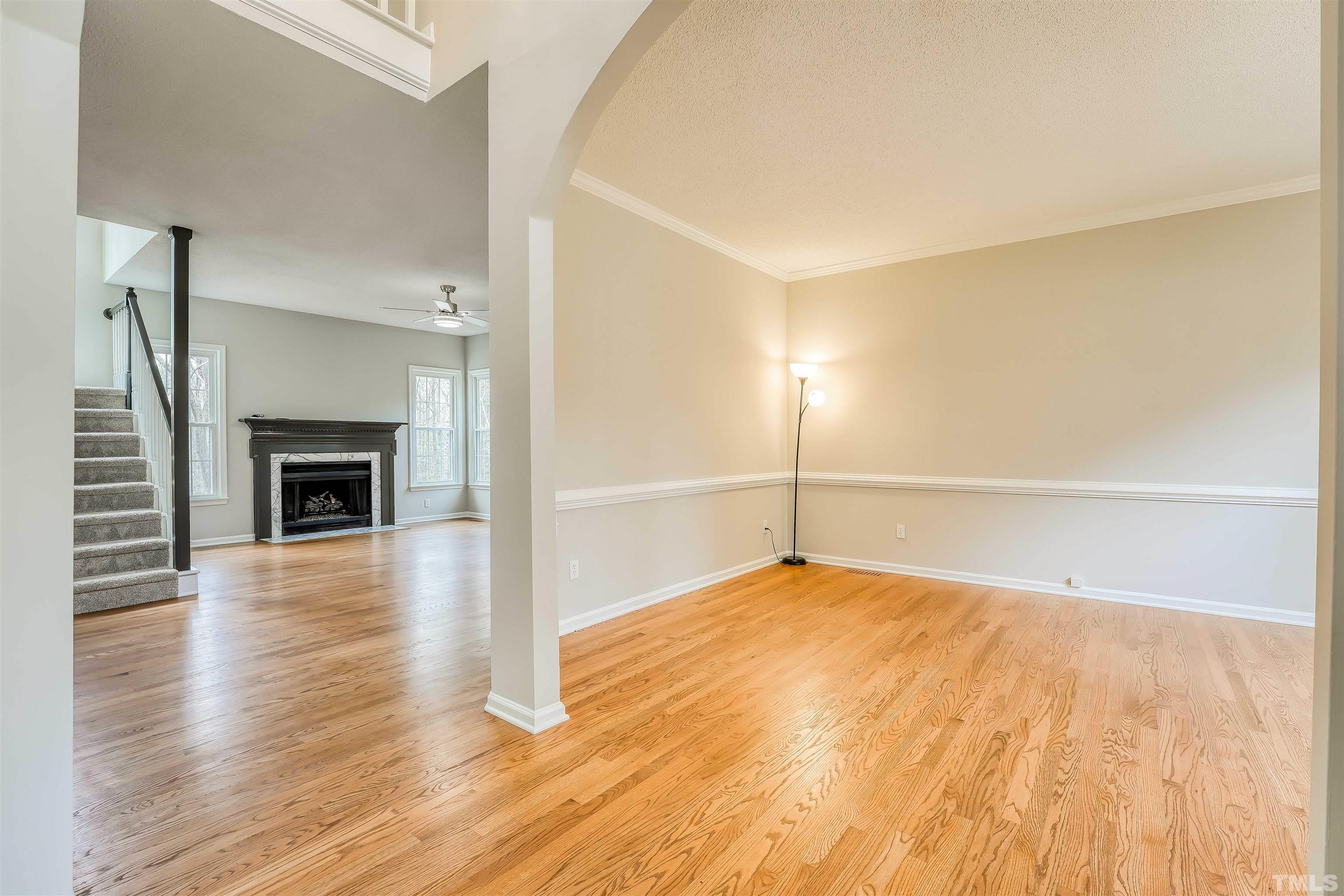 5516 Bridford Place Raleigh, NC 27613 - Photo 5 of 20 a view of an empty room with wooden floor and a fireplace