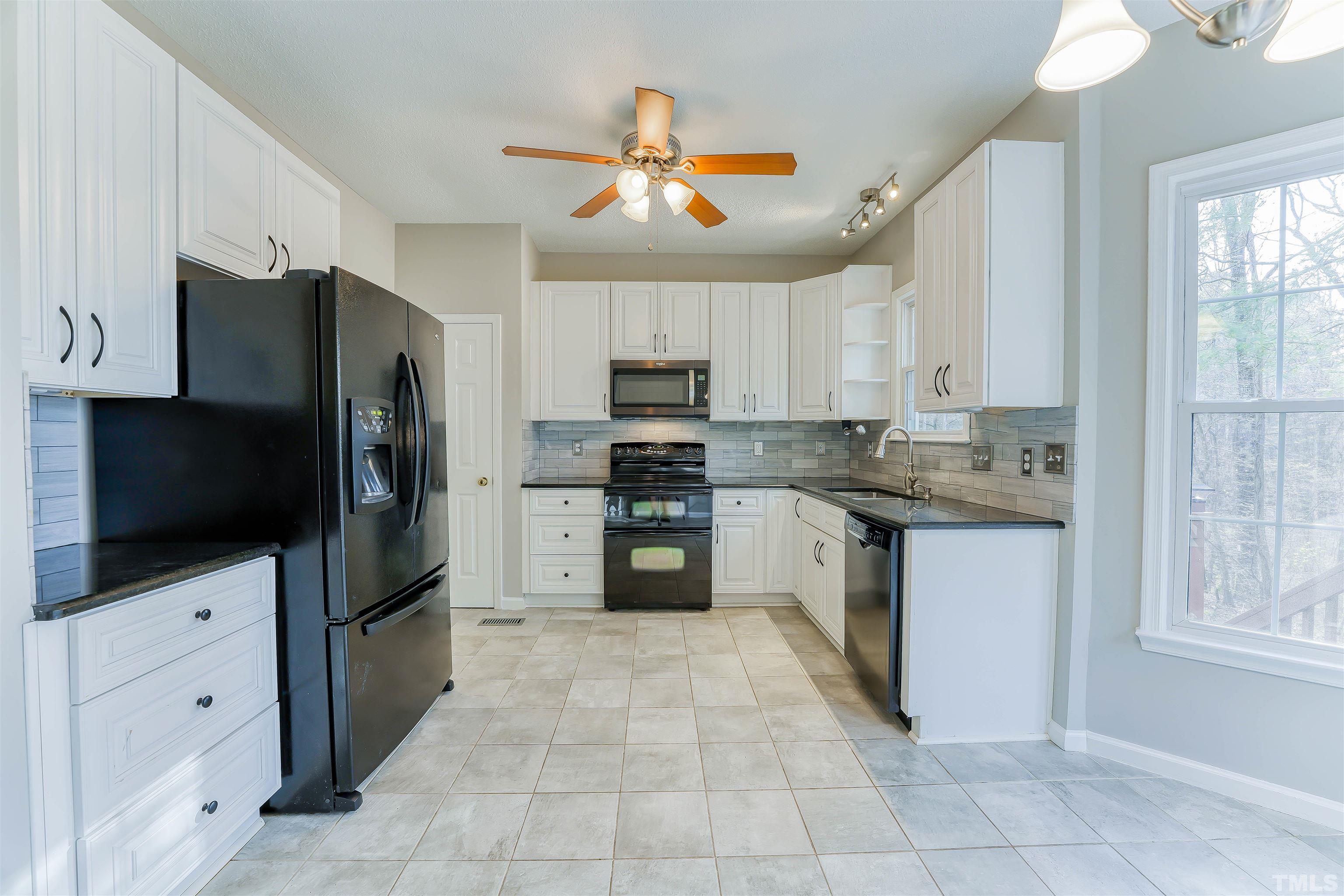 5516 Bridford Place Raleigh, NC 27613 - Photo 8 of 20 a kitchen with granite countertop a refrigerator and a stove top oven