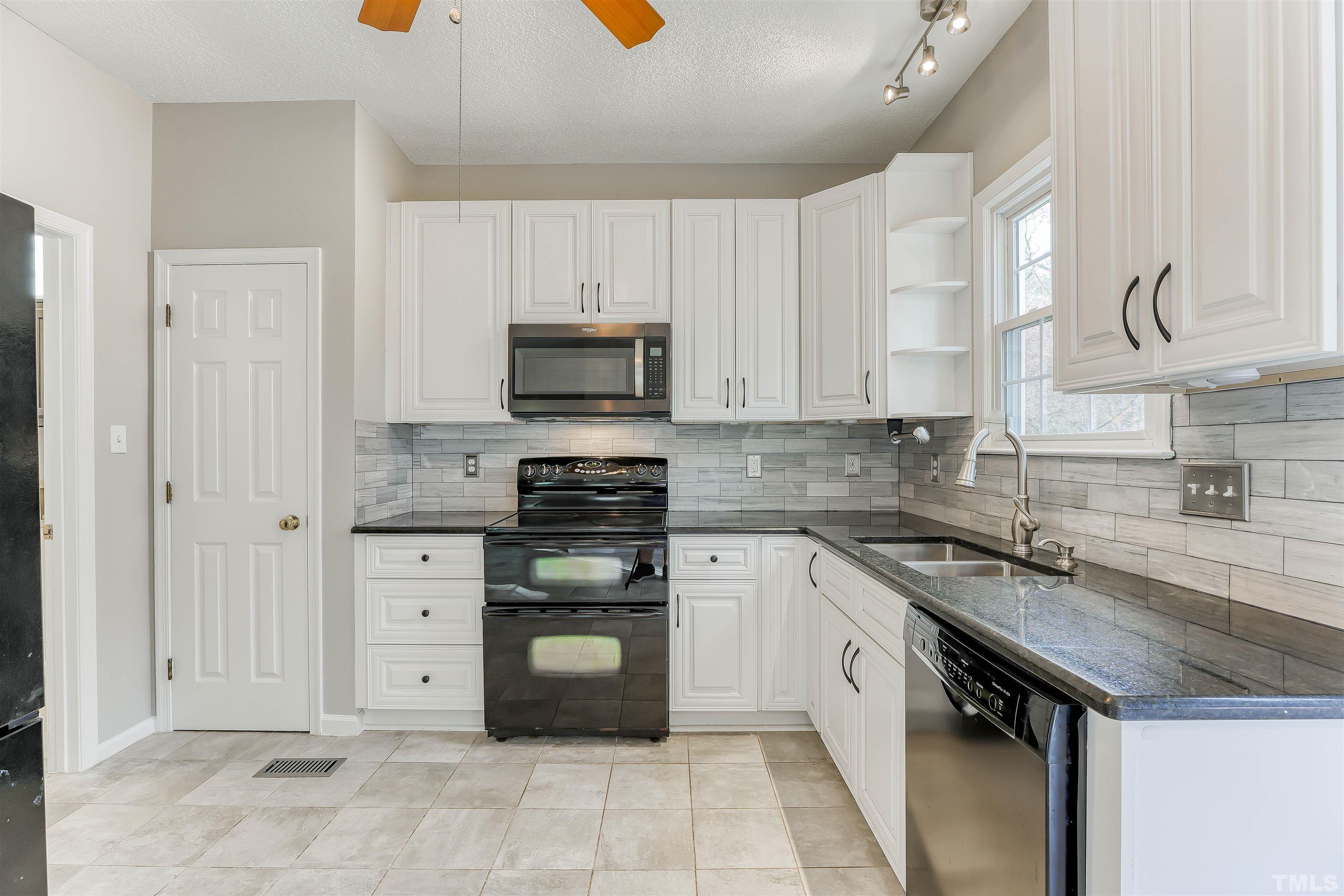 5516 Bridford Place Raleigh, NC 27613 - Photo 9 of 20 a kitchen with a sink a stove and cabinets