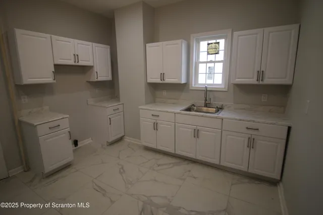 a kitchen with cabinets appliances and a window