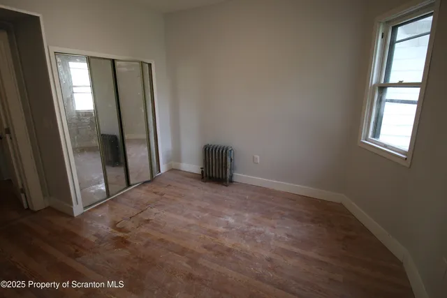 an empty room with windows and closet