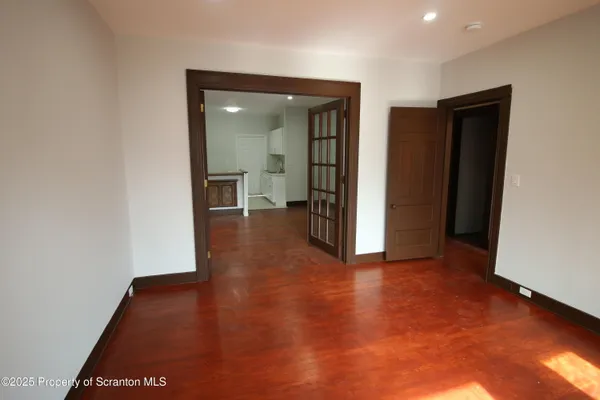 an empty room with wooden floor and closet