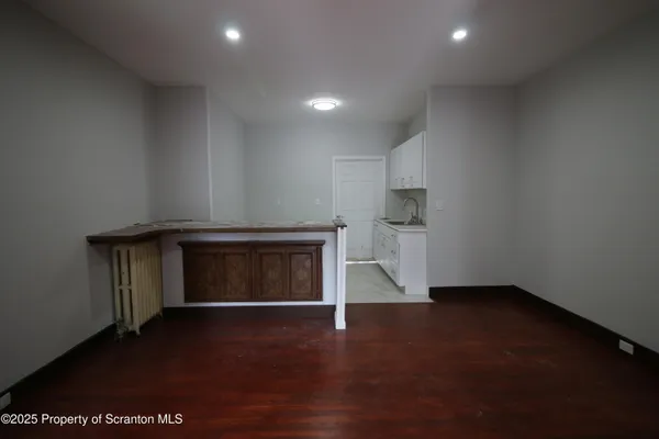 an empty room with a fireplace and wooden floor