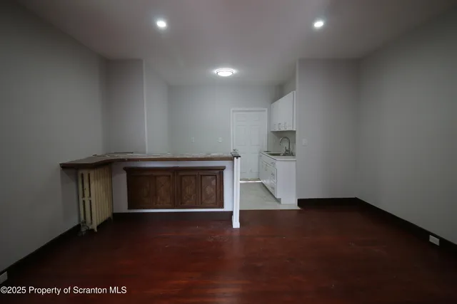 an empty room with a fireplace and wooden floor
