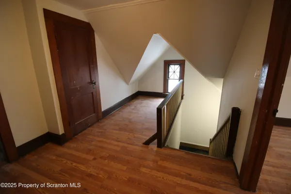 a view of hallway with stairs and wooden floor