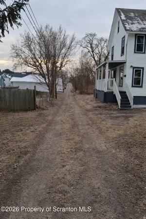 a view of a grey house with a yard