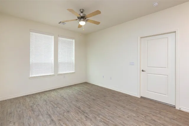 an empty room with wooden floor and window