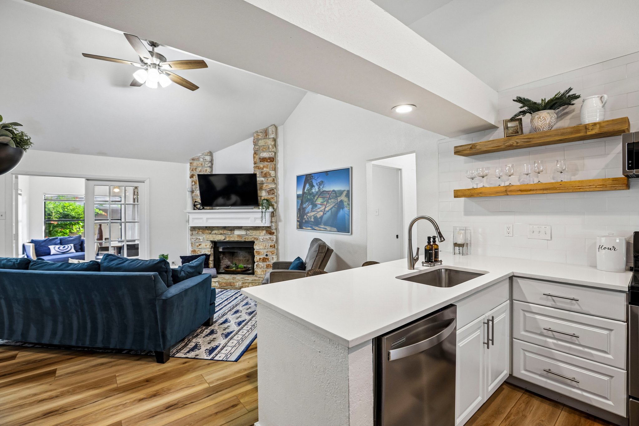 16725 Whitebrush Loop Austin, TX 78717 - Photo 2 of 32 LVP floors flow through this light-filled kitchen overlooking the stone-accented fireplace.