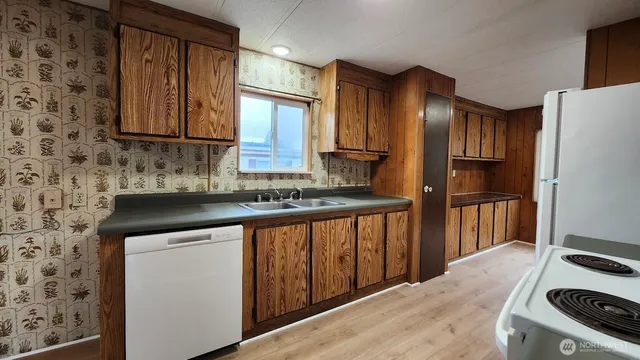 a kitchen with granite countertop wooden cabinets a refrigerator and a sink