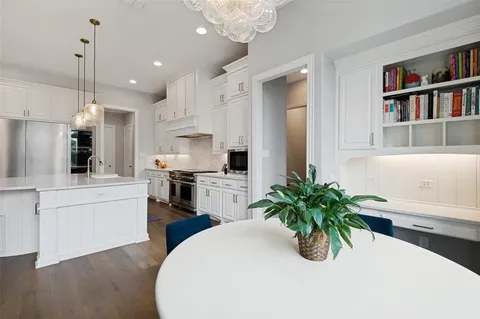 a kitchen with white cabinets and refrigerator