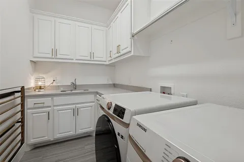 a utility room with sink cabinets and wooden floor