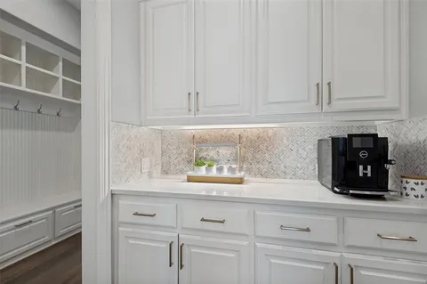 a kitchen with white cabinets and a window