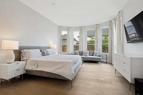 a bedroom with a large bed and a flat tv screen on a dresser