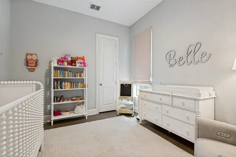 a view of bedroom with baby crib and cabinet